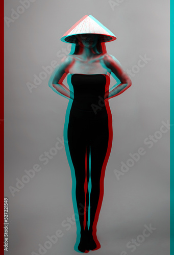 Black and white studio shot of slim and sexy woman with cone-shaped Asian cane hat and black tights till breast covered body and hiding half face in shade. Red and blue color split futuristic effect
