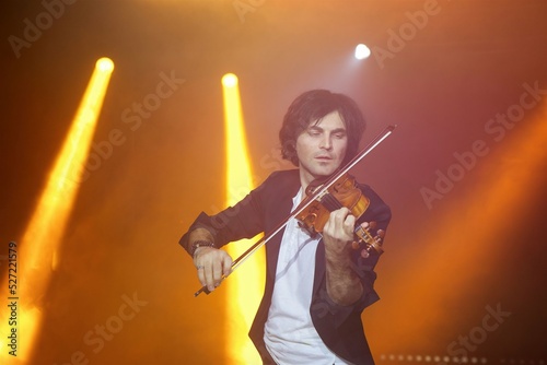Violinist a player with a violin instrument in his hands. Artist of classical music or alternative music direction. Concept of stage art
