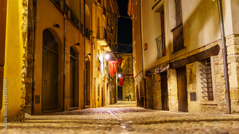 Picturesque alley with medieval stone houses at night in the town of Besalu, Girona, Catalonia.