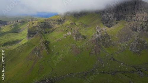 Aerial fly over above the Old man of Stor on the Isle of skye through the clouds with sunbursts during sunris photo