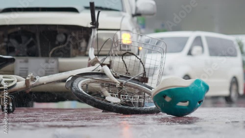 Bicycle helmet spinning and falling down bicycle on the road after traffic accident on a raining day