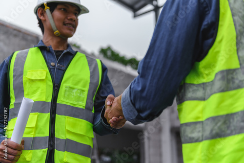 Close-up hand of Civil Engineer with contractor partners are shaking their hands in construction building, agreement of partners in contract. Handshake of civil engineer business concept.