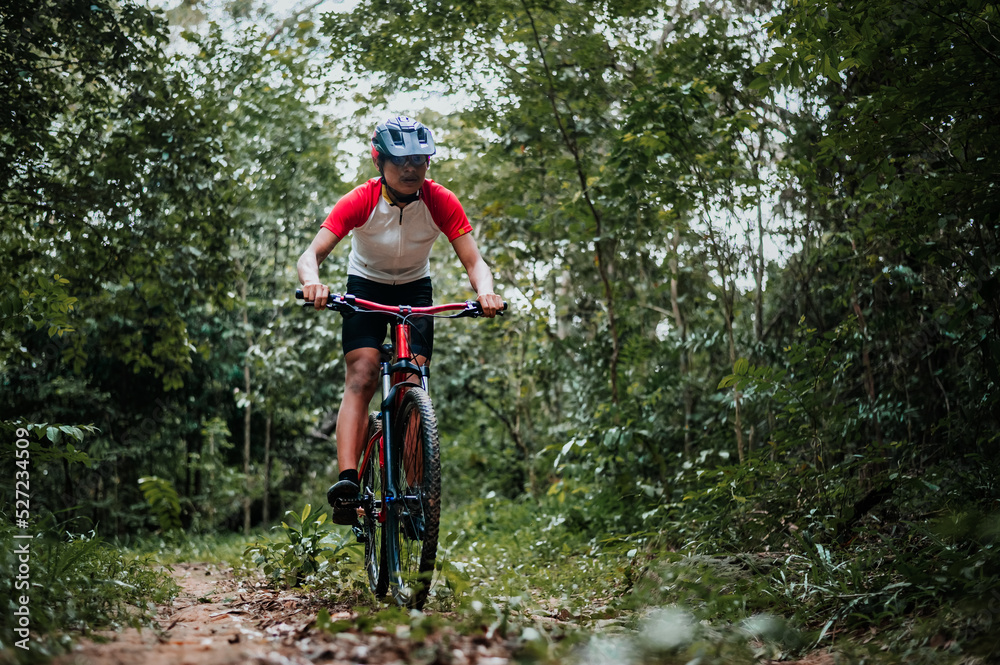 Mountain bikers ride MTB, mountain bike downhill to the extreme. Asian man rides MTB, mountain bike downhill in the wild to extremes. Extreme Sport and MTB, mountain bike downhill Concept. Mountain bikers ride MTB, mountain bike downhill to the extreme. Asian man rides MTB, mountain bike downhill in the wild to extremes. Extreme Sport and MTB, mountain bike downhill Concept.