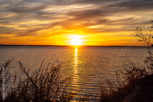 Fiery orange sunset sky. Countryside Landscape Under Scenic Colorful Sky At Sunset Dawn Sunrise. Sun Over Skyline, Horizon. Warm Colours.