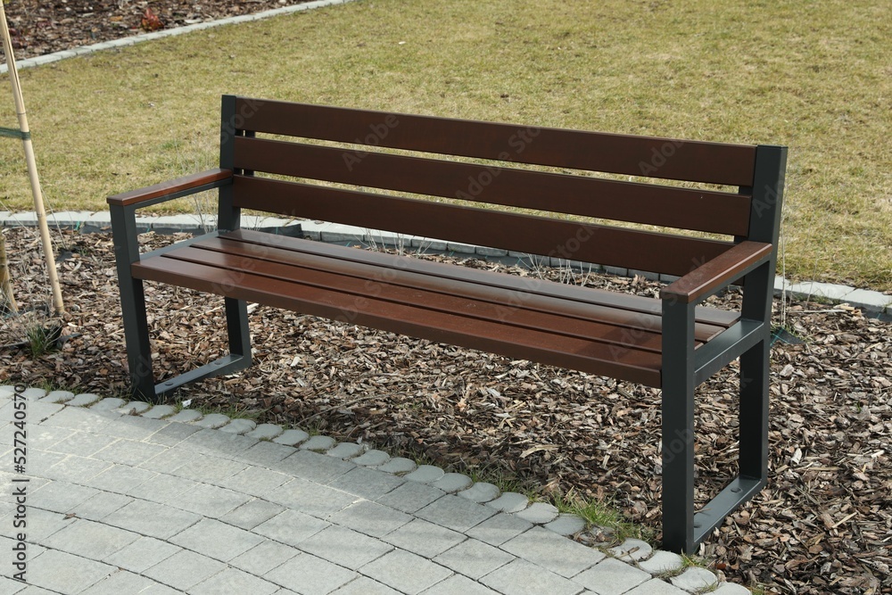 Empty wooden bench in park on spring day Empty wooden bench in park on spring day