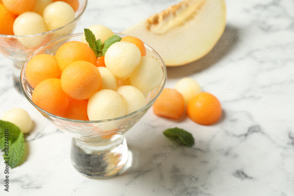 Melon balls and mint on white marble table, closeup. Space for text Melon balls and mint on white marble table, closeup. Space for text