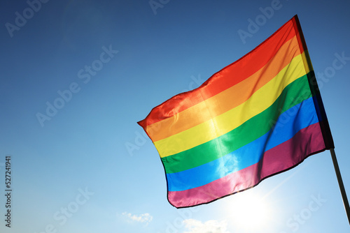 Bright LGBT flag fluttering against blue sky  space for text. Lesbian concept