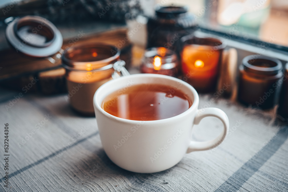 A cup of herbal tea with burning candles, aesthetically warm photo A cup of herbal tea with burning candles, aesthetically warm photo