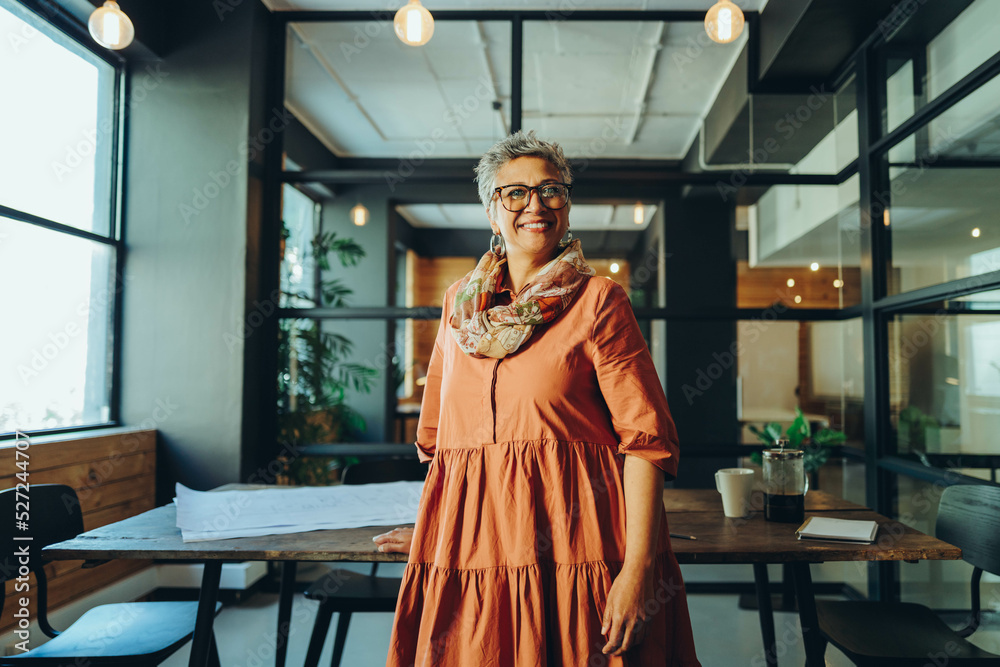 Naklejka premium Mature businesswoman smiling happily in an office