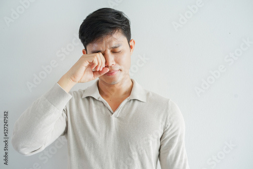 close up young man using hand to rubs eye after feeling uncomfortable sensation for health care concept