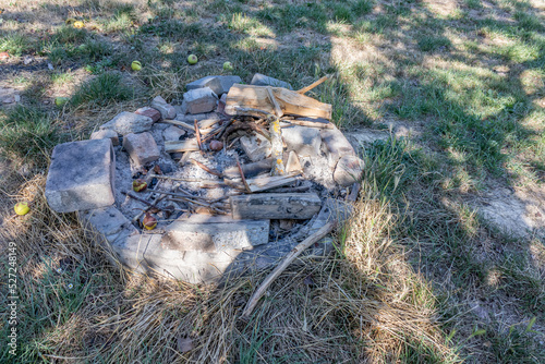 Billede på lærred Field with an unlit campfire with gray and black extinguished ashes against gree