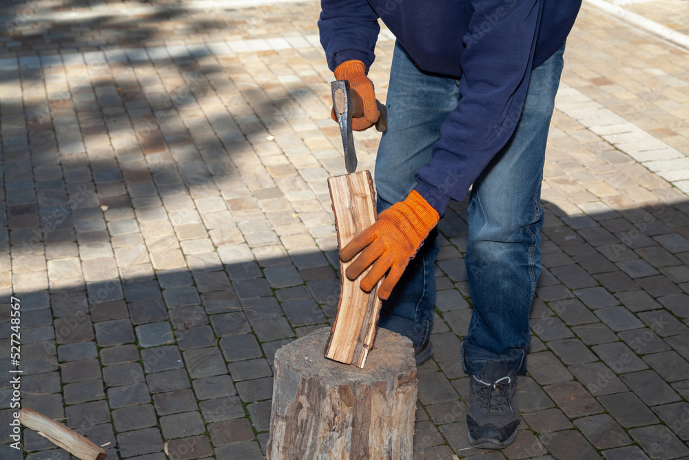 Man in jeans chopping wood in yard.. Man in jeans chopping wood in yard..