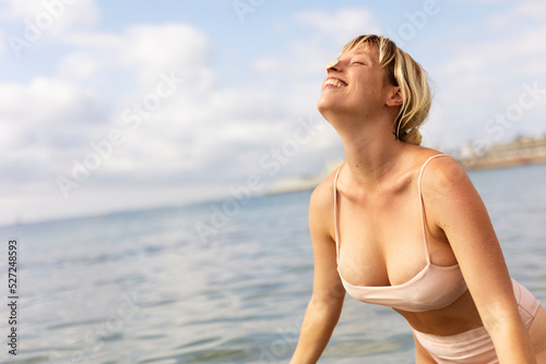 Beautiful woman swimming in the ocean. Smiling blonde girl enjoy in sunny day..