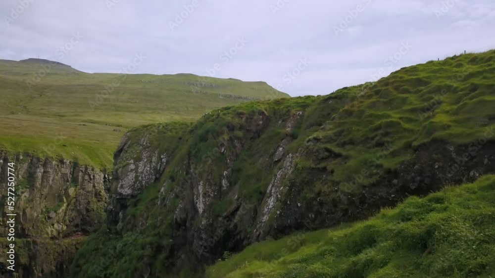 Green cliffs of Faroe islands in cloudy weather Green cliffs of Faroe islands in cloudy weather