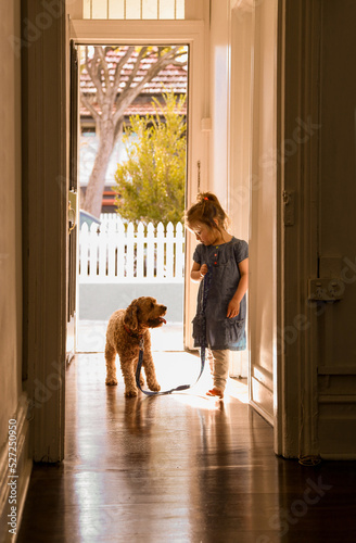 silhouette shot of a little girl with a dog on a leash in the corridor