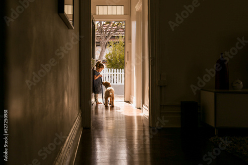 silhouette shot of a little girl with a dog on a leash in the corridor photo