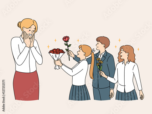 Children in uniform greeting happy teacher 