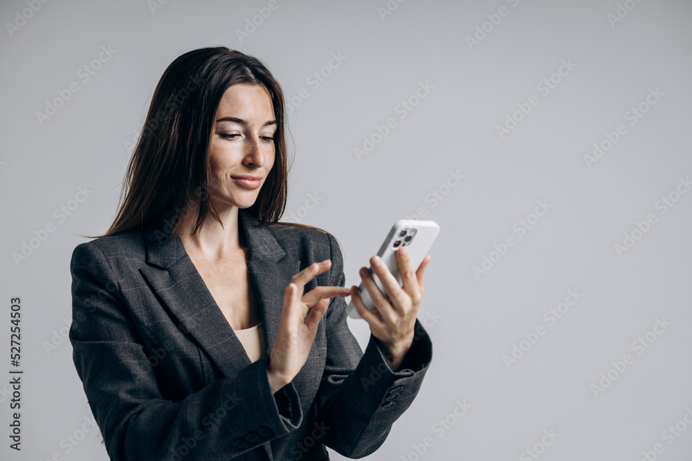 Stylish girl businessman holding phone and typing text.