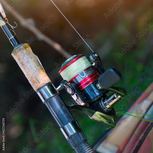 Spinning rod with a reel for catching predatory fish on a natural background