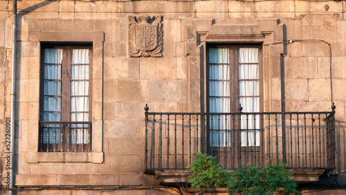 Balcón en fachada monumental de piedra en antiguo palacio en casco histórico photo