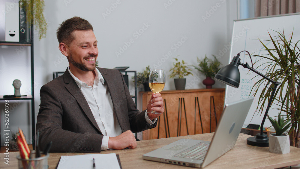 Businessman working on laptop celebrate successful contract agreement with colleague client at office workplace desk. Freelancer man drinking champagne. Online remote video call conversation job Businessman working on laptop celebrate successful contract agreement with colleague client at office workplace desk. Freelancer man drinking champagne. Online remote video call conversation job