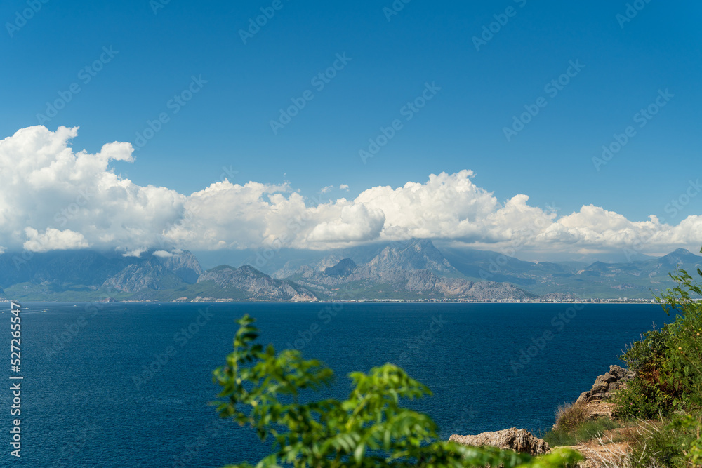 A coastal town at the foot of the mountains and the sea. Clouds in the mountains
