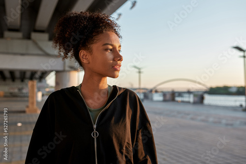 Profile of black sportswoman looking away in city
