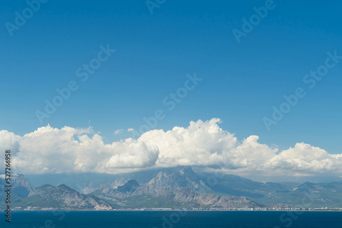 A coastal town at the foot of the mountains and the sea. Clouds in the mountains