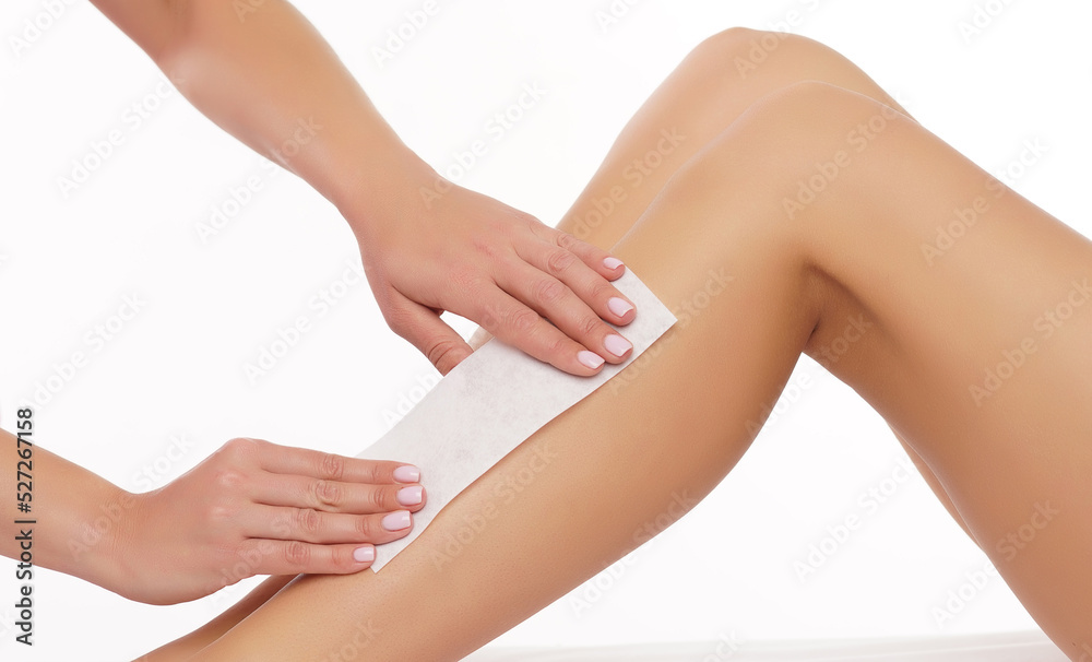 Hair removal, beauty and health concept. A young girl is getting an epilation procedure. A processional beauty worker is making depilation with hot wax. Hair removal, beauty and health concept. A young girl is getting an epilation procedure. A processional beauty worker is making depilation with hot wax.