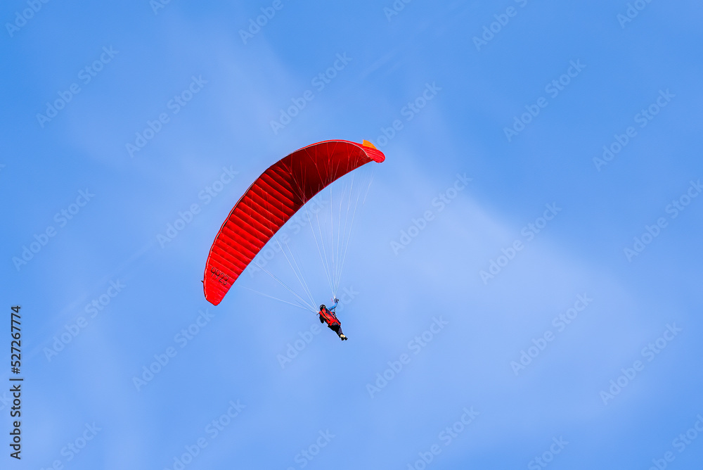 Paragliding in flight. Red and orange paraglider. Paragliding in flight. Red and orange paraglider.