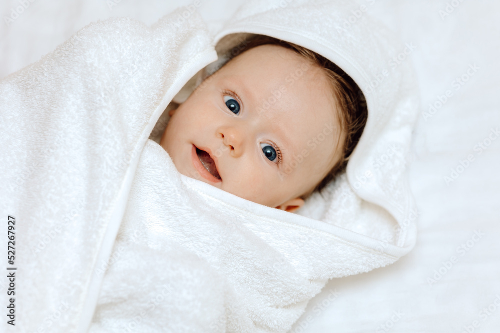 Portrait of a baby, Happy smiling baby in a towel after bathing Portrait of a baby, Happy smiling baby in a towel after bathing