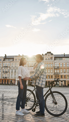 Side of couple in love with bicycles embracing