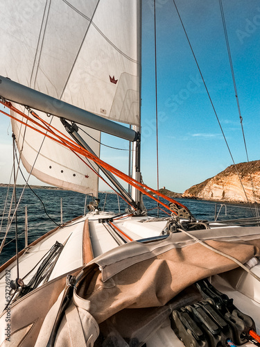 Barca a vela in mare aperto vicino alla scogliera alla luce del tramonto