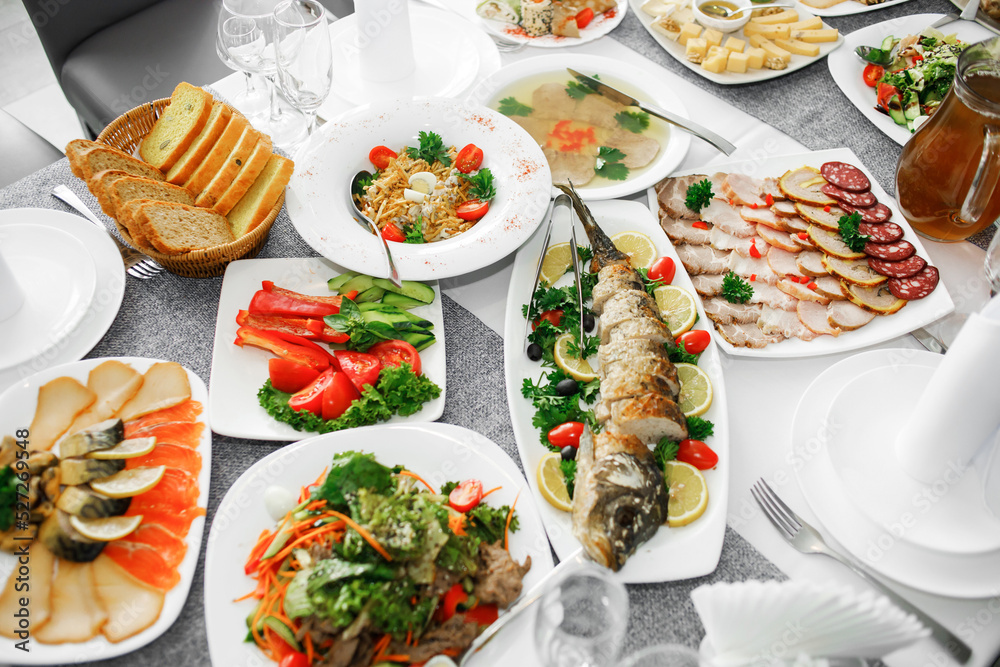 Fish dishes on the banquet table, logos, snacks, vegetables Fish dishes on the banquet table, logos, snacks, vegetables