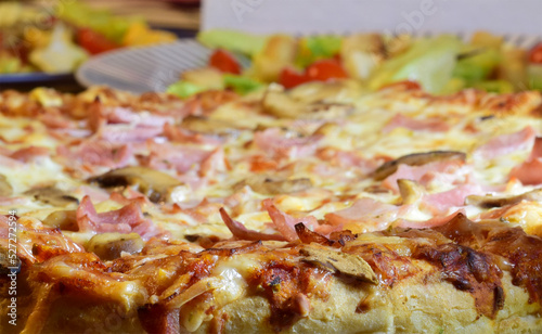 Pizza, sweet ham, cheese, tomato sauce and mushroom, in the bottom plate of assorted salad.