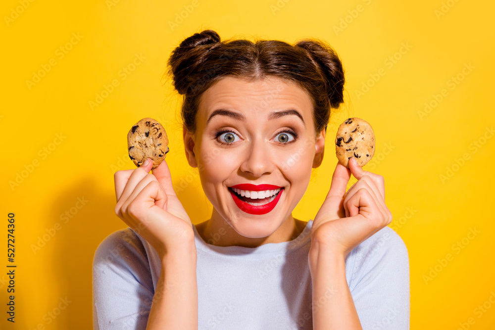 Φωτογραφία Photo of excited shiny girl dressed white shirt rising two cookies isolated yell