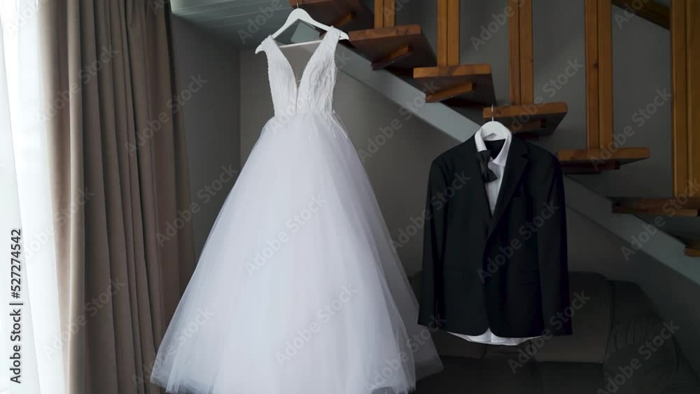 Moving camera. The dress of the bride and groom to hang in a room near stairs Moving camera. The dress of the bride and groom to hang in a room near stairs