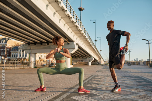 Black sports couple look at each other and stretch