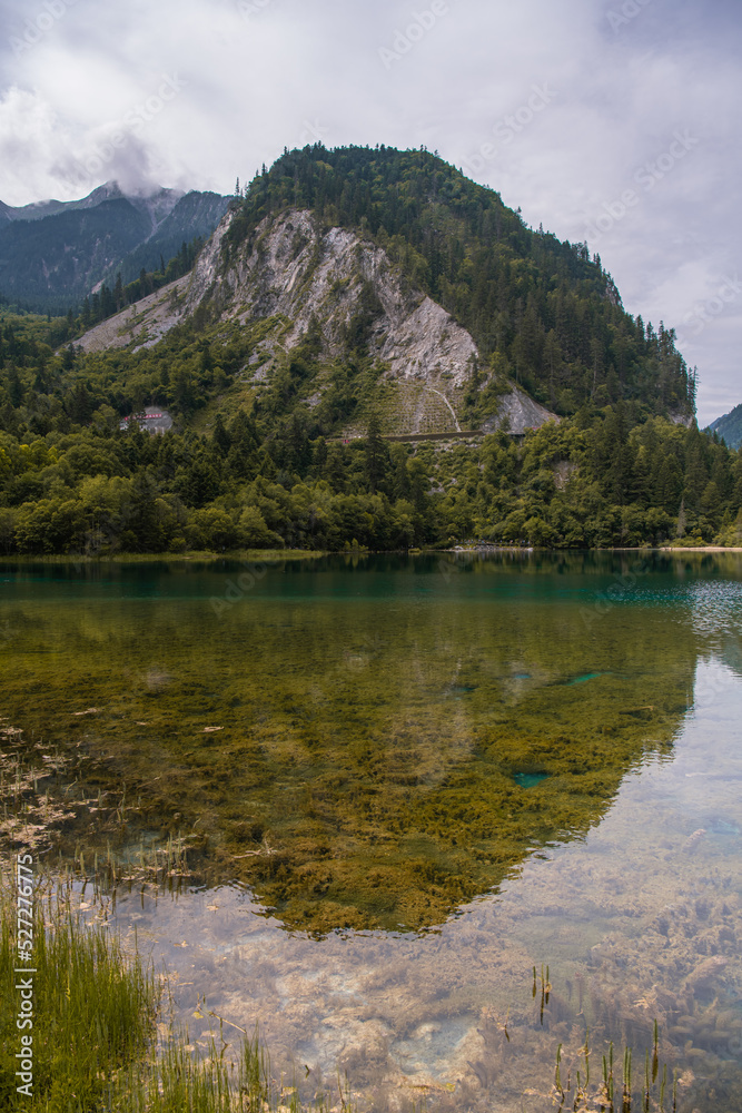 Vertical panoramic view of the two mountains reflecting from the mirror surface of the emerald turquoise Five Color Pond lake in Jiuzhaigou, Aba Tibetan Autonomous Prefecture, Sichuan, China