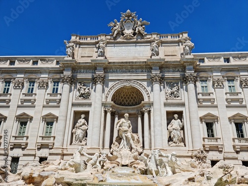 Scenic cityscape with Trevi fountain in the old city in the morning sun lights. Beautiful view of marble sculptures on a sunny day. People like take a photo near Italian landmarks. Famous palace decor