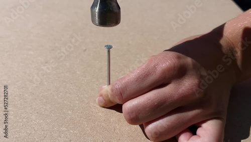 home improvement, repair and people concept - close up of hands hammering nail to wood