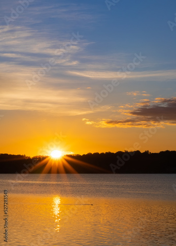 sunrise starburst over lake with otter