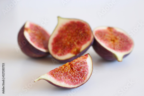 Fresh ripened purple figs. Creative composition, the decorative banner of whole and sliced exotic fruit isolated on white table background. Natural pattern. Flat lay, top view. Food photography.