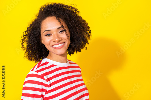Photo of brunette cute lady near empty space wear red t-shirt isolated on vibrant yellow color background © deagreez