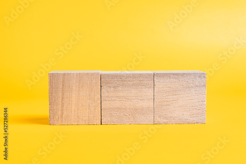 Fototapeta Naklejka Na Ścianę i Meble -  3つの木製のブロックと黄色背景　合成素材