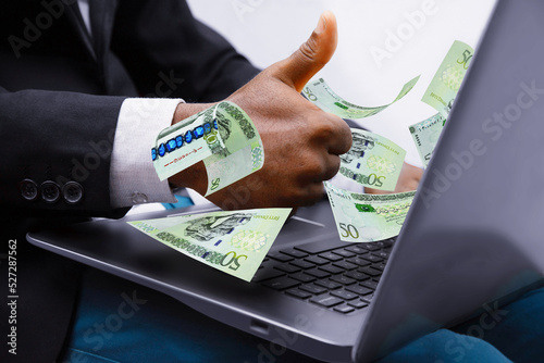 Libyan dinar notes coming out of laptop with Business man giving thumbs up, Financial concept. Make money on the Internet, working with a laptop