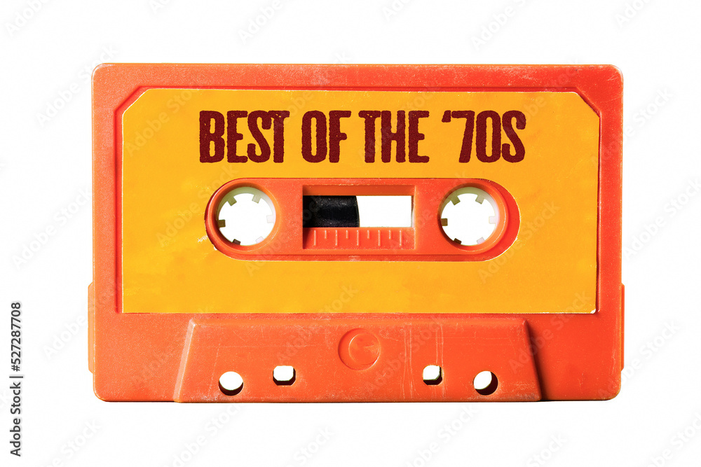 Obraz premium An old vintage orange cassette tape for easy storage of music and audio, isolated, with text on the label: best of the 70s. 