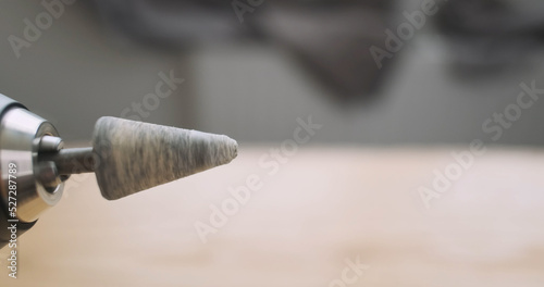 Rotation of the stone grinding head in an electric screwdriver. Rapid movement of the drill, side view, close-up.