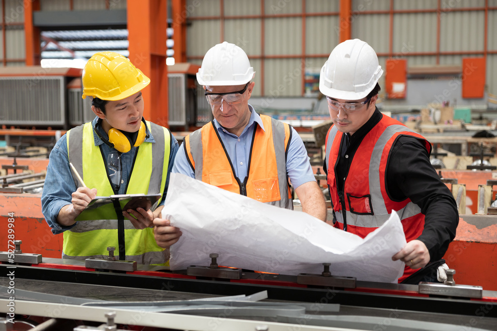 factory workers or engineer planning from work on blueprint drawing paper in the factory factory workers or engineer planning from work on blueprint drawing paper in the factory