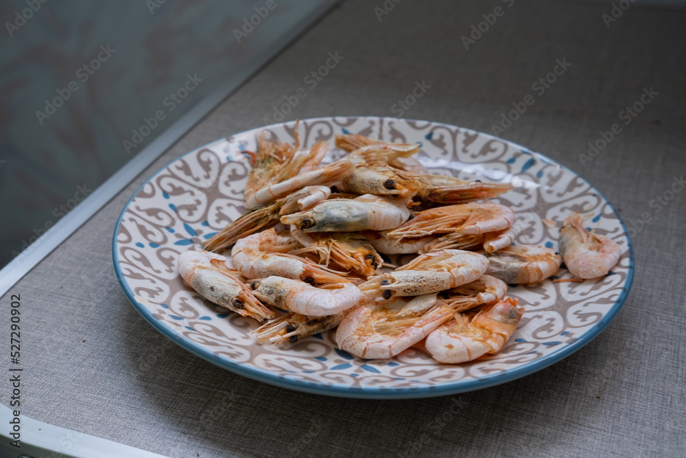 Shrimps, in a plate on the table, prepared at home on an electric grill Shrimps, in a plate on the table, prepared at home on an electric grill